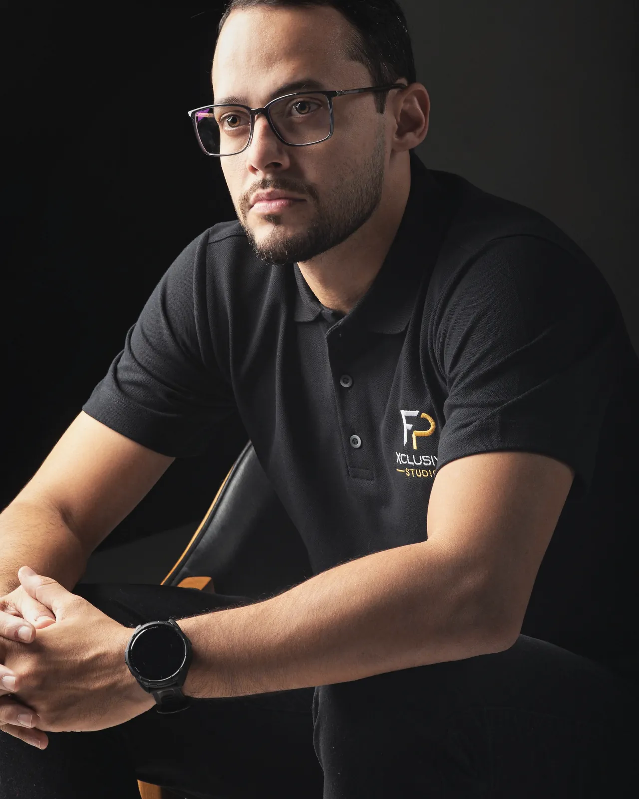 Flávio Pereira, fundador da FP Xclusive Studio, sentado, com a camisa da FP